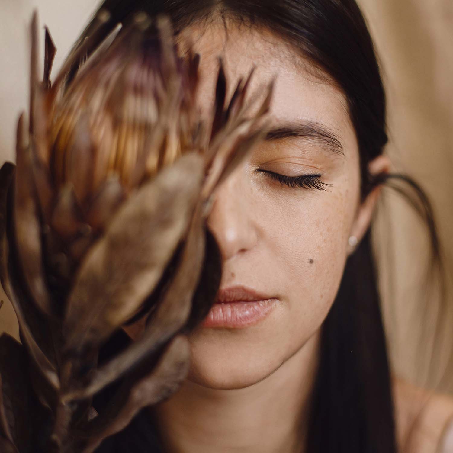 stylish-sensual-woman-holding-protea-flower-at-fac-4CXRJ23.jpg